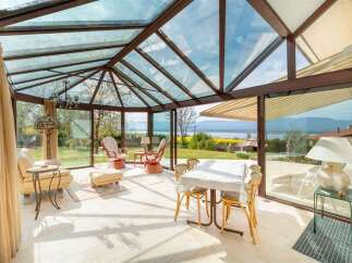 Enjoy breathtaking views from this stunning sunroom, featuring a glass ceiling and walls that flood the space with natural light.
