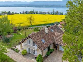 Experience serene living in this charming home, boasting a picturesque view of a vibrant yellow canola field and a tranquil lake.