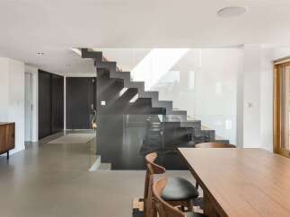 Experience modern living in this stunning home featuring a sleek, floating staircase with glass railings.