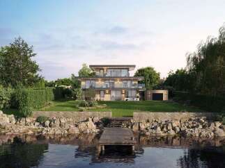 Experience luxury waterfront living in this stunning modern home, featuring expansive glass windows and multiple balconies offering breathtaking lake views.