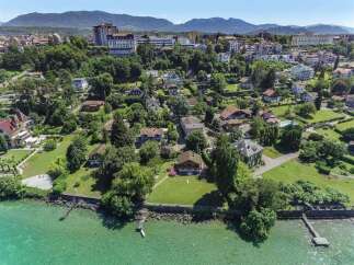 Experience lakeside living in this stunning aerial view of a charming neighborhood bordering a crystal-clear lake.