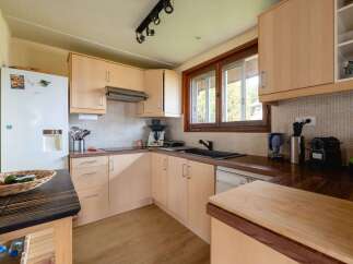 Discover this charming kitchen featuring light wood cabinetry and a tiled backsplash.
