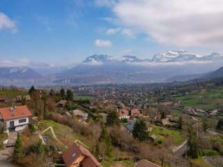 Discover this charming property nestled in a picturesque hillside setting, offering breathtaking panoramic views of a serene lake and majestic snow-capped mountains.