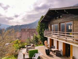 Experience the ultimate mountain retreat with this stunning wooden chalet, featuring a spacious deck with outdoor seating and a relaxing hot tub.