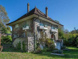 Discover this charming stone house nestled amidst lush greenery, offering a unique blend of classic architecture and natural beauty.
