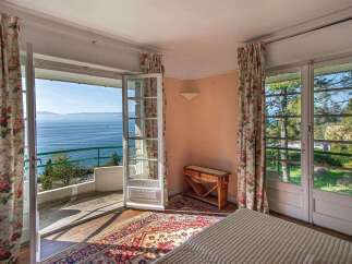 Experience breathtaking lake views from this charming bedroom, featuring French doors that open onto a private balcony.