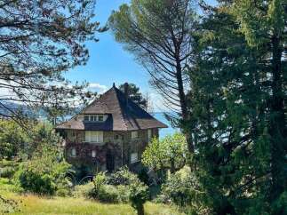 Nestled amidst lush greenery, this charming stone house offers a serene retreat with stunning water views.