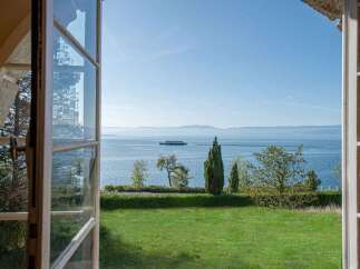 Experience breathtaking lake views from this stunning property, framed by an open window.