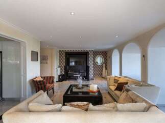 Step into this spacious living room, featuring a modern entertainment center with a large TV and stylish wallpaper.