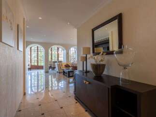 Step into this elegant entryway featuring a polished marble floor that reflects the natural light streaming through arched windows.