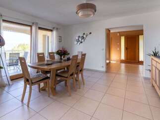 This spacious dining room features a large wooden table with six chairs, perfect for family gatherings.