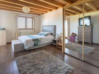 Discover this charming bedroom featuring a comfortable bed with a floral duvet and a plush rug for added warmth.