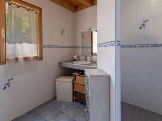 This charming bathroom features a spacious walk-in shower with a rainfall showerhead, perfect for a relaxing experience.