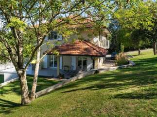 Discover this charming property nestled amidst lush greenery, featuring a beautiful house with a tiled roof and a spacious terrace perfect for outdoor relaxation.