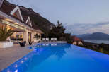 Experience luxury living with this stunning infinity pool overlooking a breathtaking mountain and lake view.