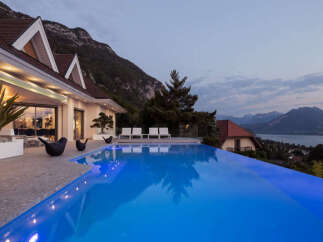 Experience luxury living with this stunning infinity pool overlooking a breathtaking mountain and lake view.