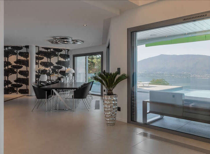Experience luxurious living with this stunning dining area featuring a modern chandelier and elegant black chairs surrounding a sleek dining table.
