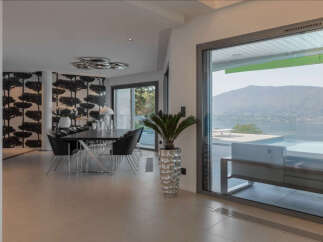 Experience luxurious living with this stunning dining area featuring a modern chandelier and elegant black chairs surrounding a sleek dining table.