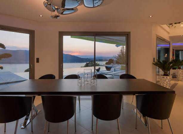 Experience luxurious modern living with this stunning dining area, featuring a sleek dark wood table and comfortable black chairs.