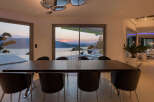 Experience luxurious modern living with this stunning dining area, featuring a sleek dark wood table and comfortable black chairs.