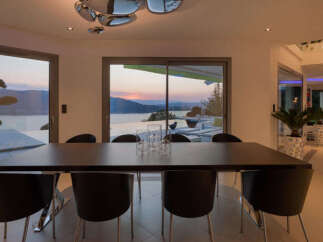 Experience luxurious modern living with this stunning dining area, featuring a sleek dark wood table and comfortable black chairs.
