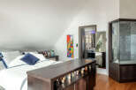 Discover this unique bedroom featuring a comfortable bed with crisp white linens and a striking blue accent pillow.