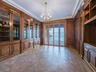 Step into this elegant library, featuring rich mahogany built-in bookshelves and a stunning parquet floor.