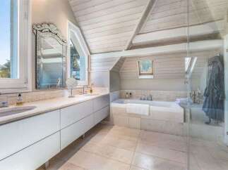 Experience luxury in this stunning bathroom featuring a deep soaking tub and a spacious vanity with dual sinks.