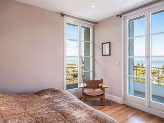 Experience breathtaking lake views from this charming bedroom, featuring large French doors that open to a private balcony.