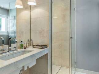 This modern bathroom features a sleek stone countertop with an integrated sink and a chrome faucet.