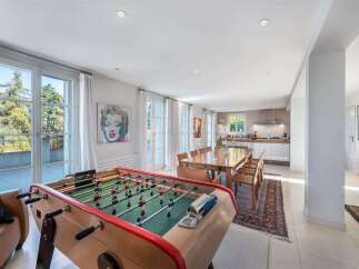 Experience modern living in this spacious open-plan home, featuring a vibrant game room with a foosball table and a stylish dining area perfect for entertaining.