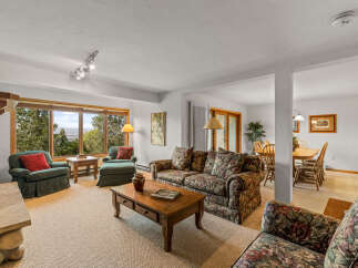 Enjoy breathtaking mountain views from this spacious living area, featuring a cozy fireplace and ample seating.