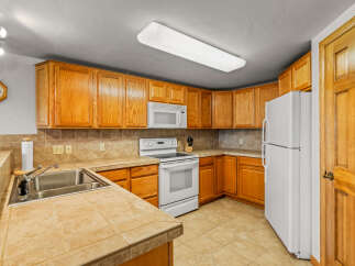 This charming kitchen features warm oak cabinetry, providing ample storage and a classic aesthetic.