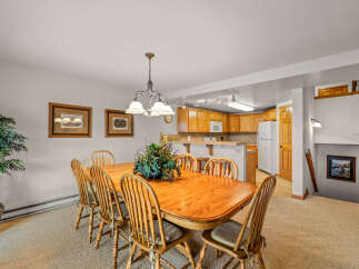 This spacious dining area features a large wooden table with six chairs, perfect for family gatherings.