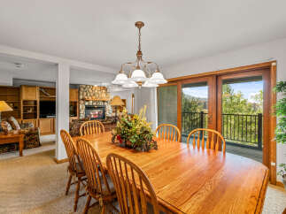 Enjoy meals with a view in this spacious dining area, featuring a large wooden table and chairs perfect for family gatherings.