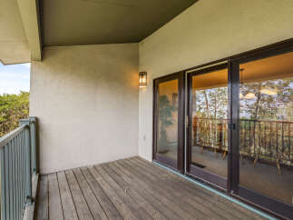 Enjoy the outdoors from this charming balcony, featuring a rustic wooden deck and a protective overhang.