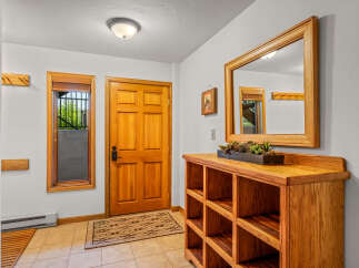 Welcome guests into this charming entryway featuring a warm wooden door and a convenient coat rack.
