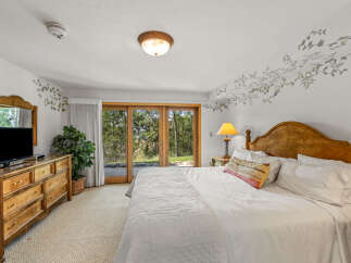 Experience serene living in this charming bedroom, featuring a cozy queen-size bed with crisp white linens and a decorative accent pillow.