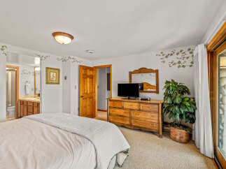 Discover comfort and convenience in this charming bedroom featuring a plush bed and a spacious wooden dresser.