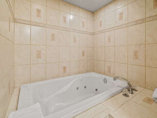 Indulge in relaxation with this luxurious corner jacuzzi tub, perfect for unwinding after a long day.