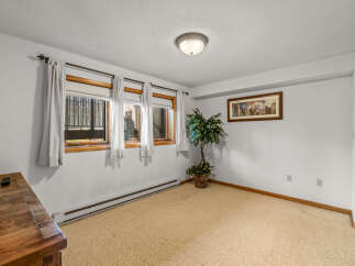 This room features a neutral-toned carpet and white walls, creating a bright and airy atmosphere.