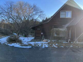 Discover this charming wooden house nestled amidst a serene winter landscape.