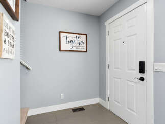 Welcome guests into this inviting entryway featuring a charming 'together is my favorite place to be' wall sign.