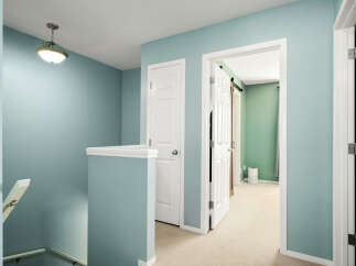 This image showcases a hallway with light blue walls and a white railing, leading to two doorways.