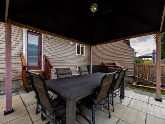 Enjoy outdoor living with this covered patio featuring a spacious dining set perfect for al fresco meals.