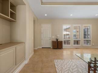 Step into this inviting entryway featuring a bright white door and elegant built-in shelving.