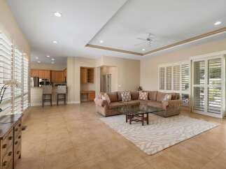 This spacious living area features a large sectional sofa, a glass coffee table, and a stylish area rug, perfect for relaxing and entertaining.