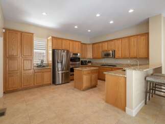 This spacious kitchen boasts beautiful light oak cabinetry, offering ample storage and a warm, inviting aesthetic.