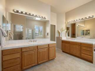 This spacious bathroom features a double vanity with ample counter space and storage, perfect for any household.
