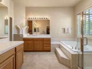 This spacious master bathroom features a large soaking tub with a step-up entrance, perfect for unwinding after a long day.